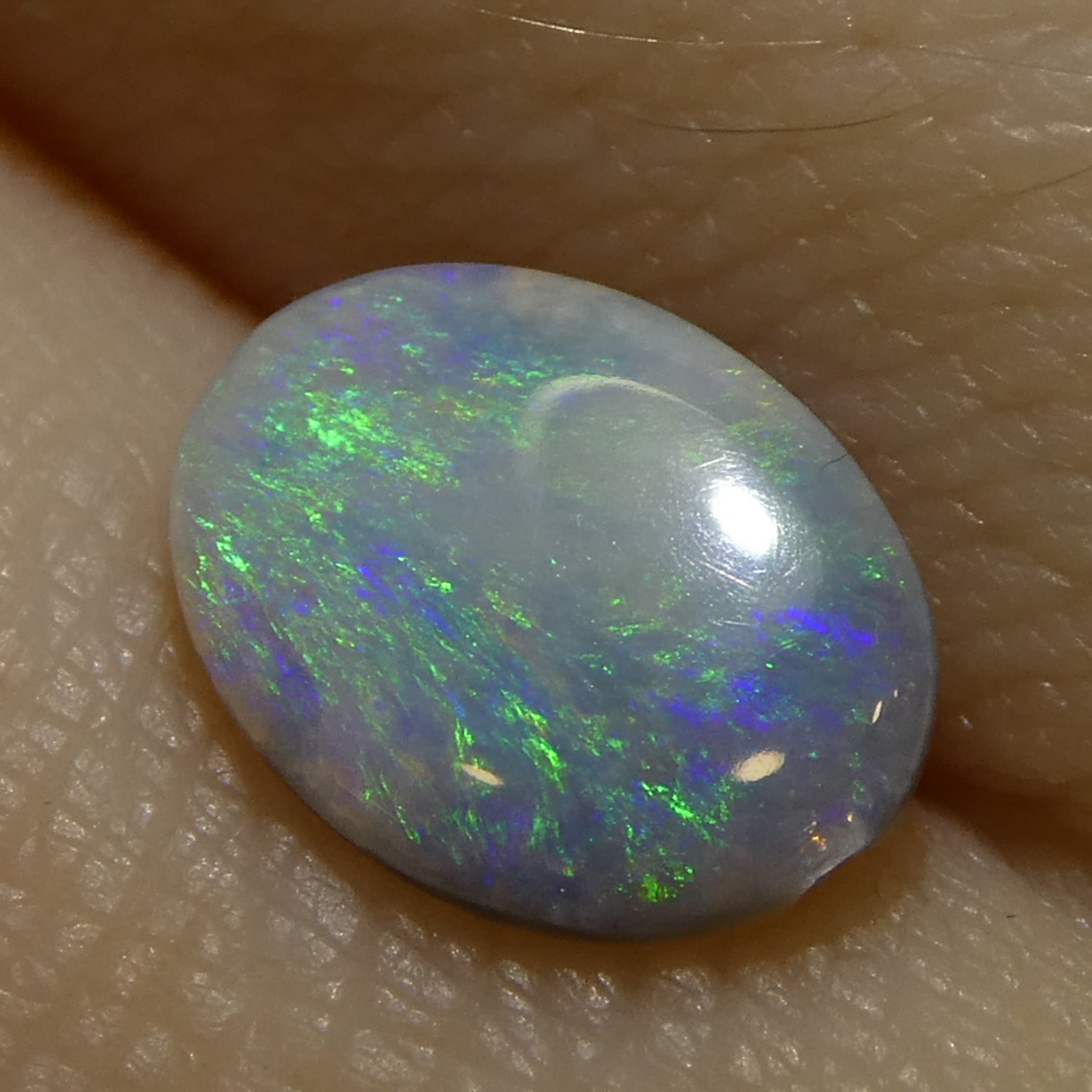 0.47ct White Oval Cabochon Opal from Australia with Play of Color, premium gemstone by SkyJems Canadian gem specialists